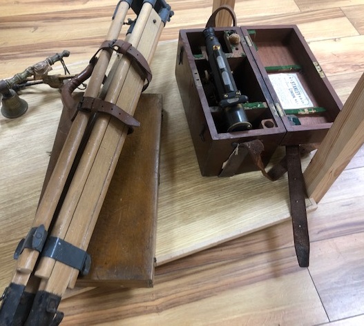 A theodolite and tripod and set of drawing instruments